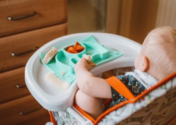 A baby in a highchair eating food