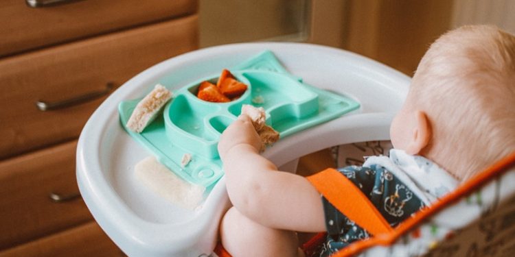 A baby in a highchair eating food